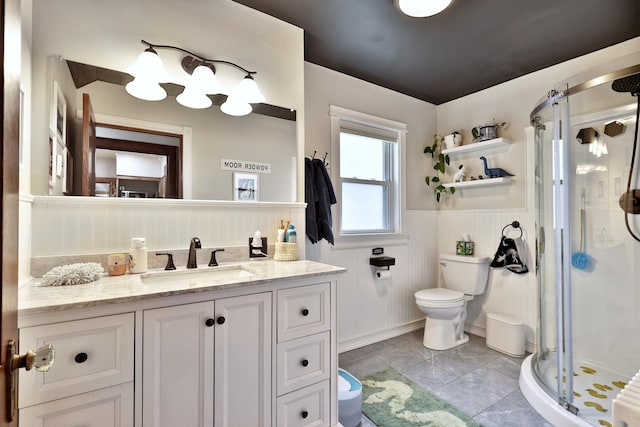 bathroom featuring toilet, a stall shower, wainscoting, and vanity