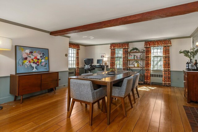dining area featuring crown molding, hardwood / wood-style floors, and beam ceiling