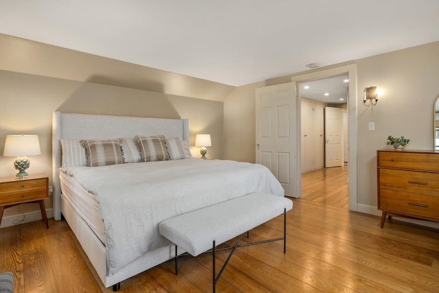 bedroom with baseboards, recessed lighting, and light wood-style floors