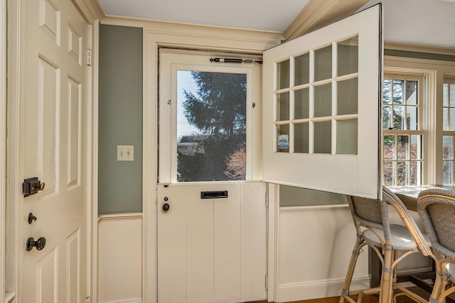 entryway featuring a decorative wall and crown molding