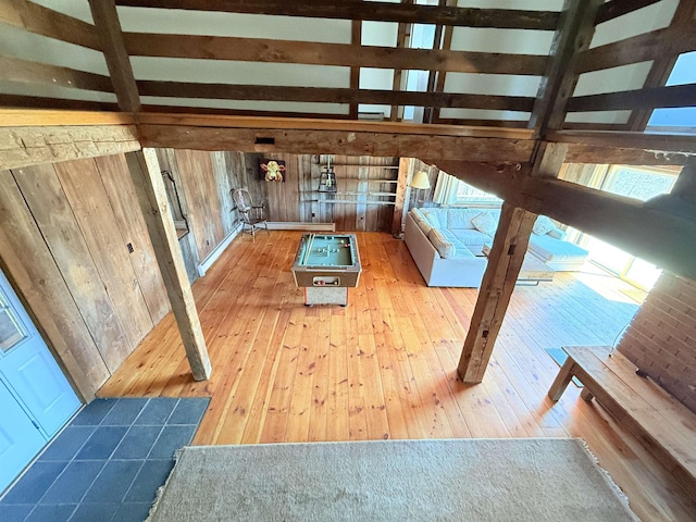unfurnished living room featuring wood-type flooring and wooden walls