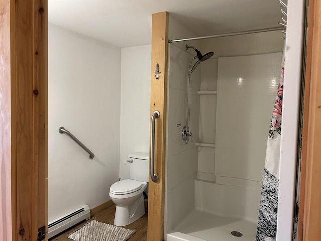 full bathroom with toilet, wood finished floors, a shower stall, and a baseboard heating unit