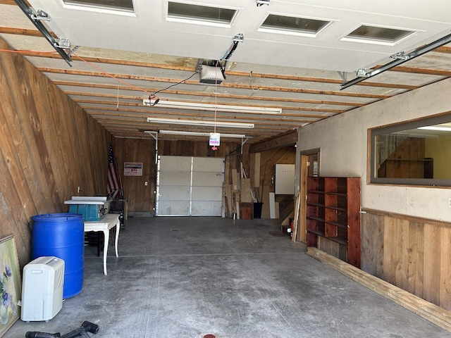 garage with a garage door opener and wooden walls