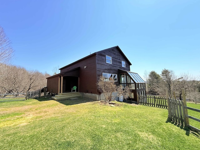 back of property with a yard and fence