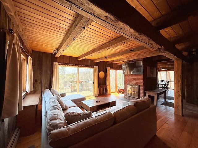 living room featuring beamed ceiling, wood-type flooring, wood walls, wood ceiling, and a baseboard radiator