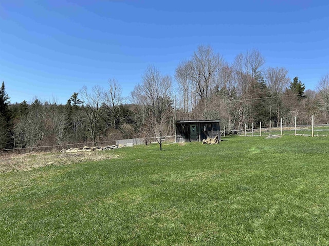 view of yard with fence and a view of trees