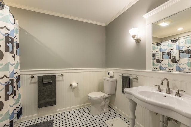 full bathroom featuring ornamental molding, a wainscoted wall, and toilet