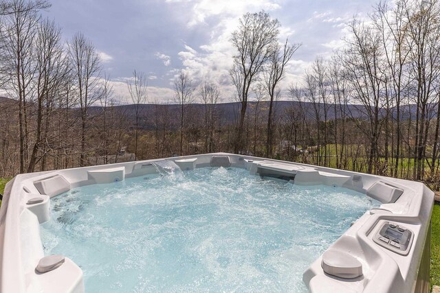 view of swimming pool featuring a mountain view and a hot tub