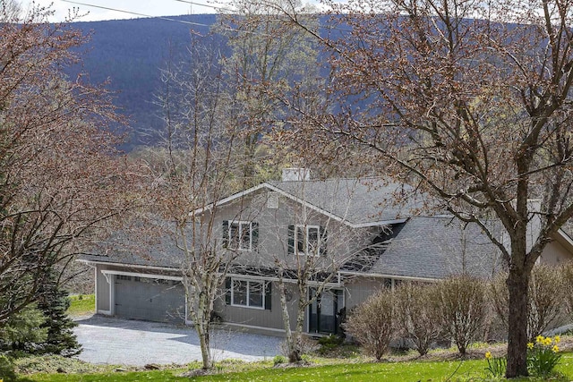 traditional home featuring an attached garage and a chimney