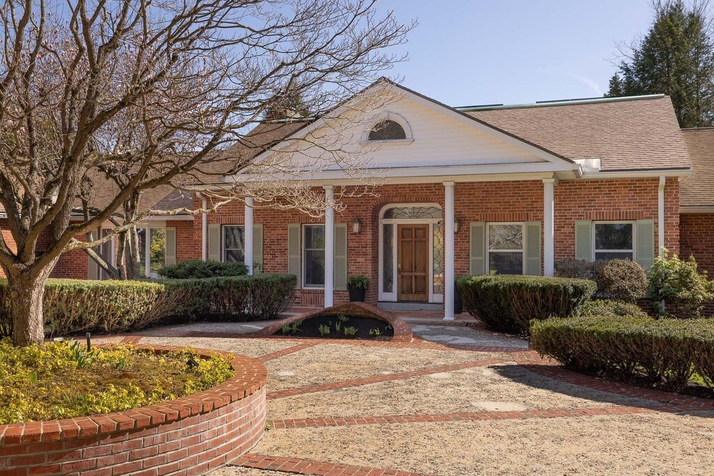 9 Hartswood Rd, Dover, NH 03820 - neoclassical home featuring a porch, a shingled roof, and brick siding