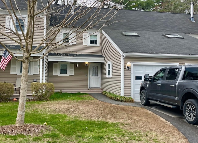 multi unit property with a garage and a shingled roof