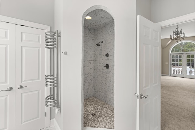 bathroom with a chandelier, radiator, and tiled shower