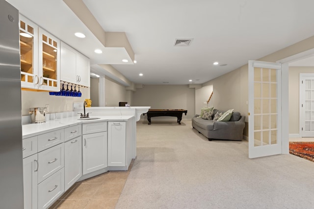 kitchen with a sink, light colored carpet, visible vents, open floor plan, and recessed lighting