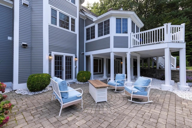 view of patio / terrace with a wooden deck, a sunroom, and stairs