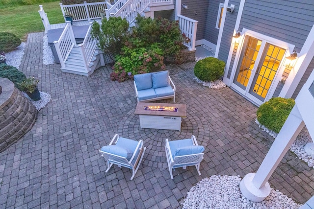 view of patio with an outdoor living space with a fire pit and stairs