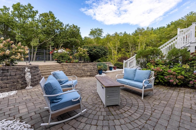 view of patio / terrace with an outdoor living space, fence, and stairs