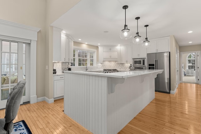 kitchen featuring white cabinetry, decorative backsplash, light wood-style flooring, stainless steel appliances, and recessed lighting