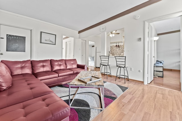 living room with ornamental molding, ceiling fan, wood finished floors, and baseboards