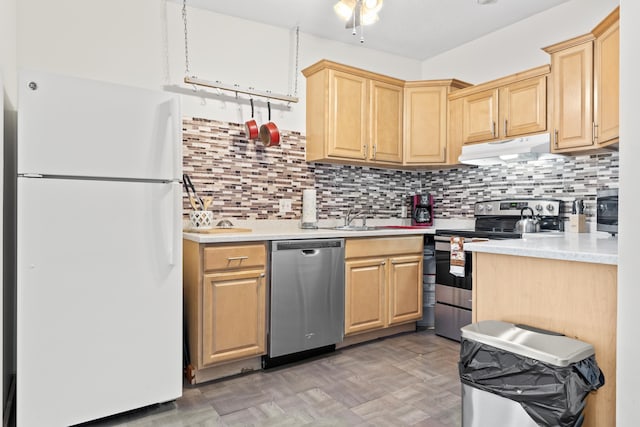 kitchen with under cabinet range hood, appliances with stainless steel finishes, light countertops, and light brown cabinetry