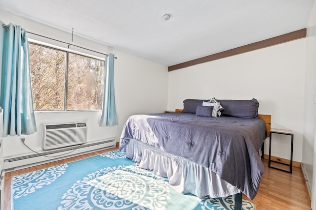 bedroom featuring baseboard heating and wood finished floors