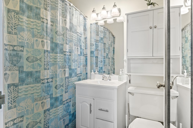 bathroom with curtained shower, toilet, and vanity