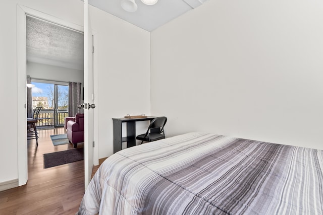 bedroom featuring a textured ceiling and wood finished floors