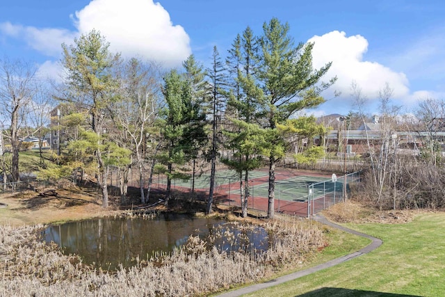 exterior space with a tennis court and fence