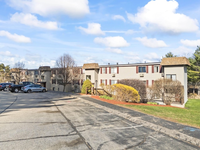 view of building exterior with a residential view and uncovered parking