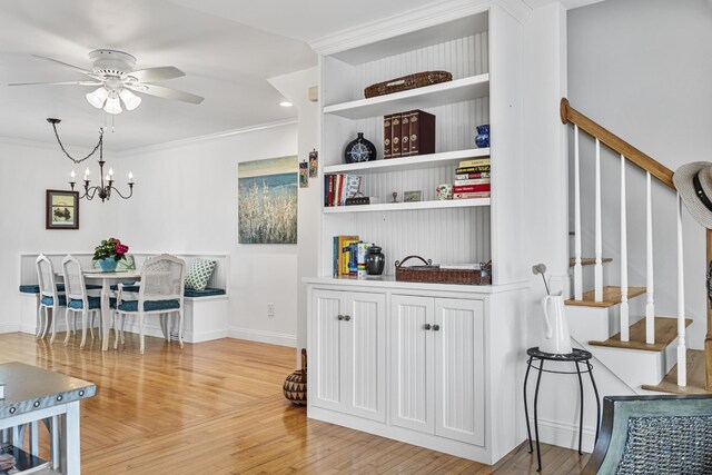 46A River St Unit A, Seabrook, NH 03874 - interior space featuring crown molding, stairway, baseboards, wood finished floors, and ceiling fan with notable chandelier
