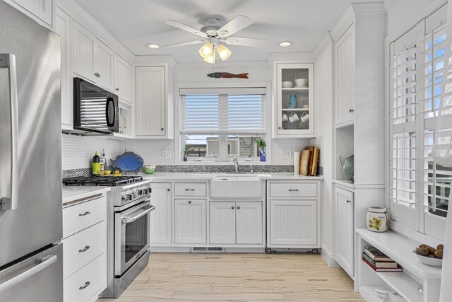 46A River St Unit A, Seabrook, NH 03874 - kitchen with white cabinetry, stainless steel appliances, light countertops, and backsplash