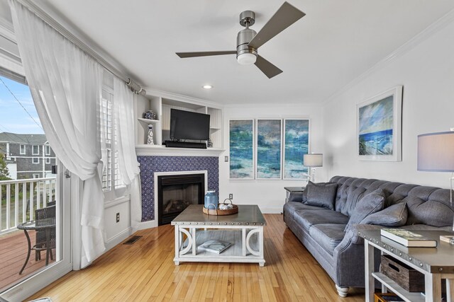 46A River St Unit A, Seabrook, NH 03874 - living area with crown molding, baseboards, wood-type flooring, a fireplace, and a ceiling fan