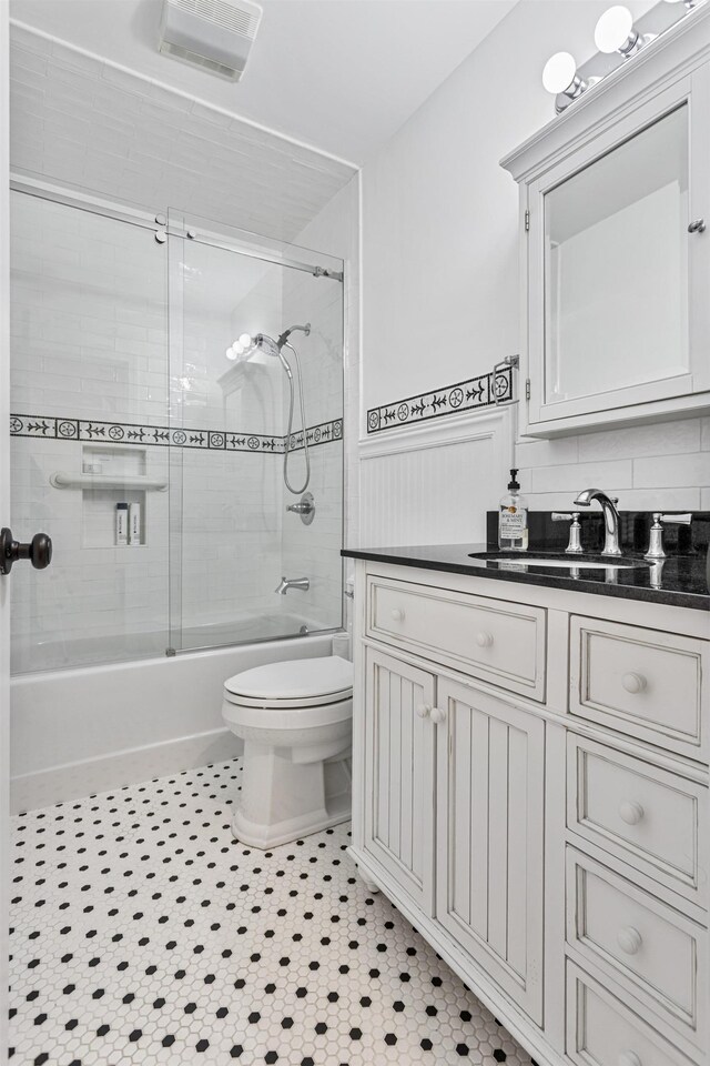 46A River St Unit A, Seabrook, NH 03874 - full bathroom featuring shower / bath combination with glass door, vanity, toilet, a wainscoted wall, and visible vents