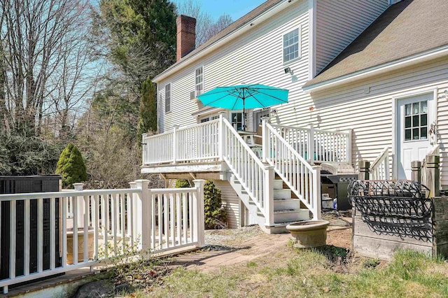 exterior space featuring a chimney, stairs, and a wooden deck