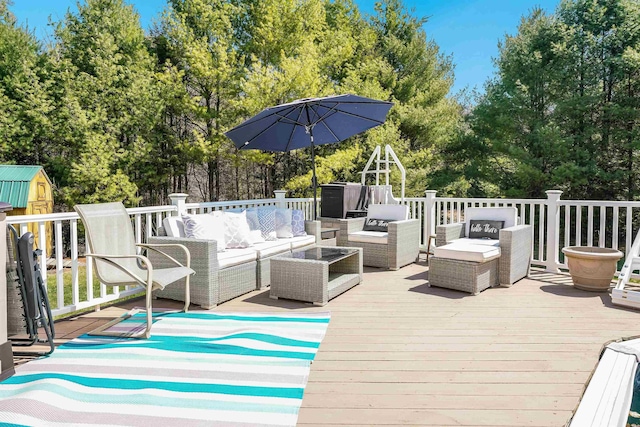 wooden deck with an outbuilding, a shed, and an outdoor living space