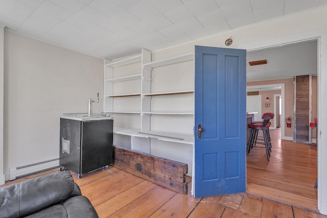 living room featuring a baseboard heating unit and hardwood / wood-style flooring