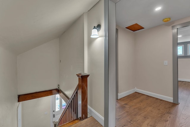 stairway with baseboards, recessed lighting, wood finished floors, and vaulted ceiling