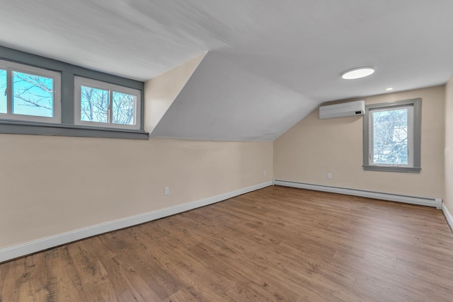 bonus room featuring baseboards, plenty of natural light, and an AC wall unit