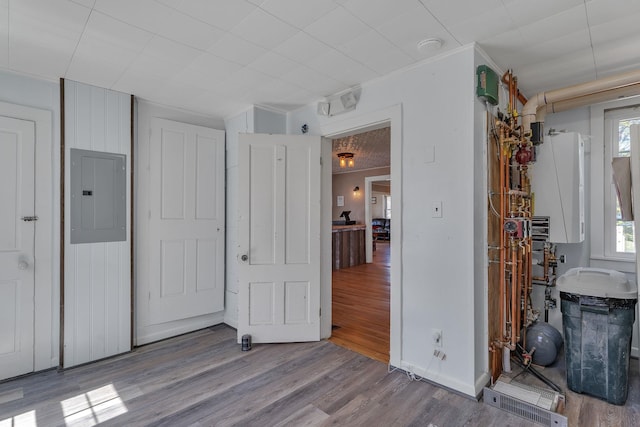 unfurnished bedroom with ornamental molding, wood finished floors, and electric panel