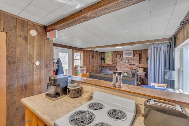 kitchen featuring wood walls, electric range, and beam ceiling