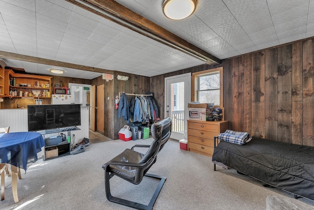 carpeted bedroom with wooden walls, beamed ceiling, and a closet