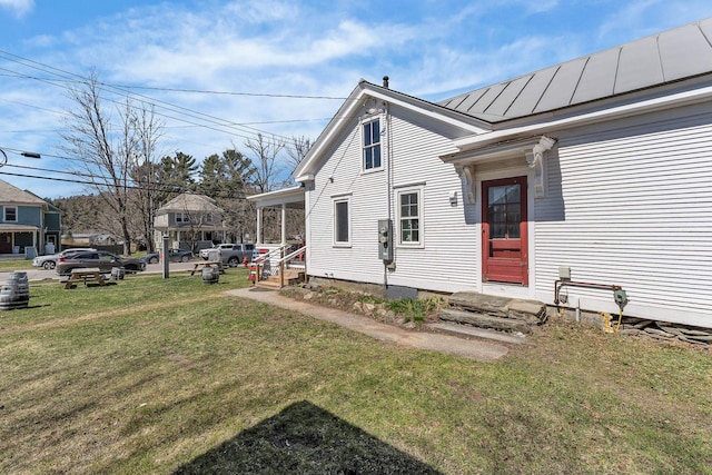 view of front facade featuring a standing seam roof, metal roof, and a front lawn