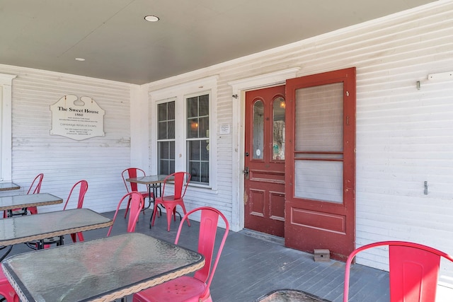 view of exterior entry with a porch and outdoor dining area