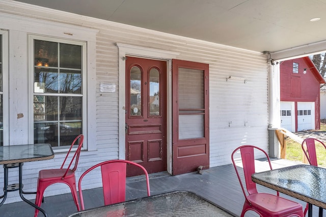 doorway to property featuring covered porch and outdoor dining area