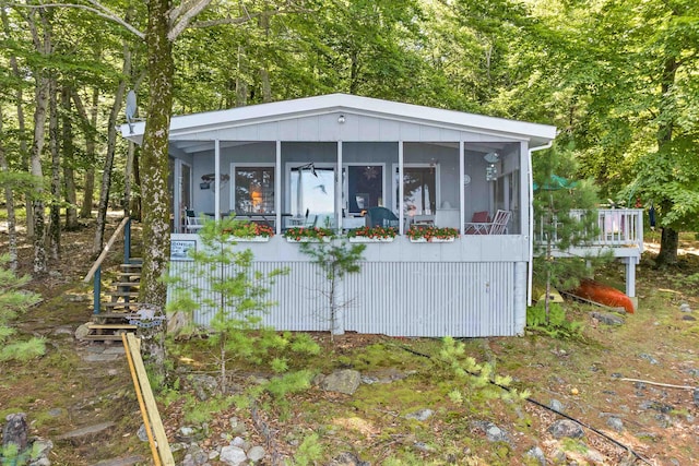view of outbuilding featuring stairs and a sunroom