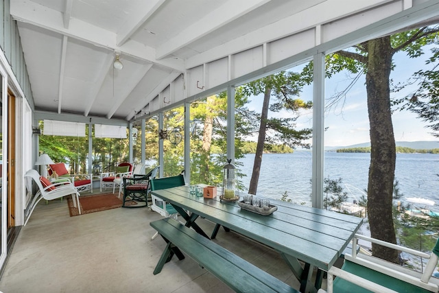 sunroom / solarium with a water view, outdoor dining area, and plenty of natural light