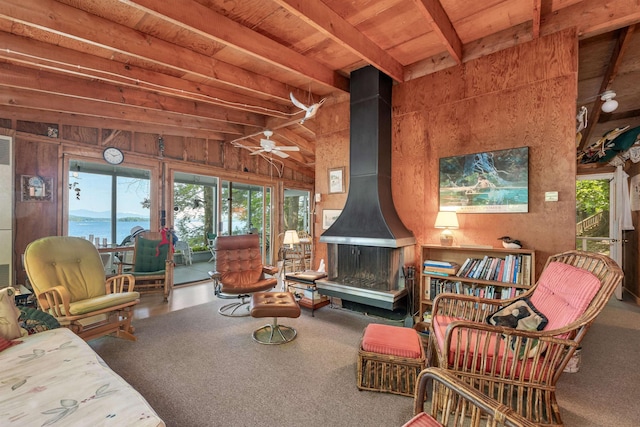 living room with a wood stove, lofted ceiling with beams, ceiling fan, a water view, and wood ceiling