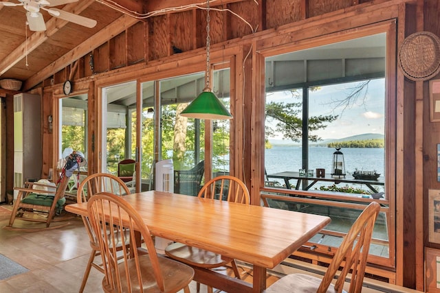 interior space featuring a water view, wood walls, and lofted ceiling
