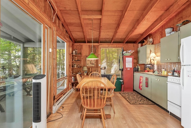 dining space with baseboard heating, light wood-style flooring, and a healthy amount of sunlight