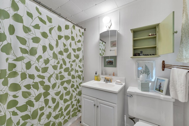 bathroom featuring toilet, vanity, and a shower with curtain