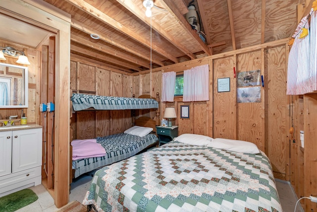 bedroom featuring wooden walls and a sink